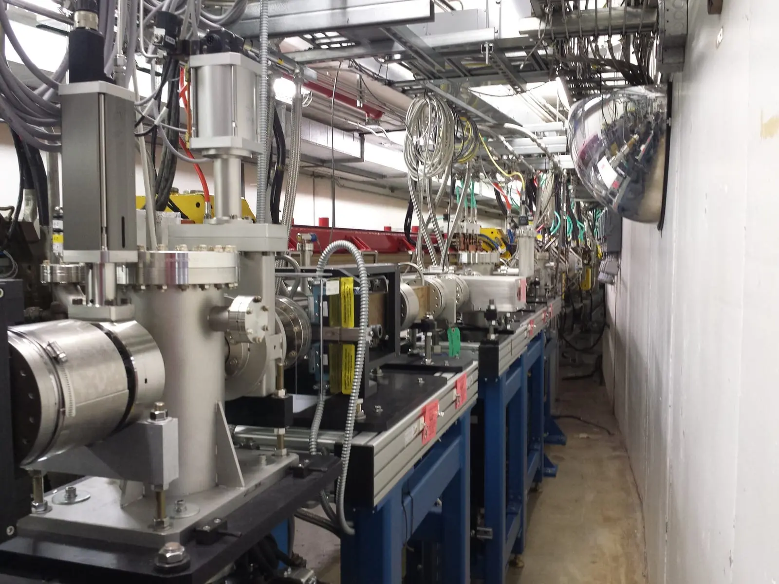 Vacuum chambers, magnets and cabling inside the curved storage ring tunnel of the Advanced Photon Source synchrotron.