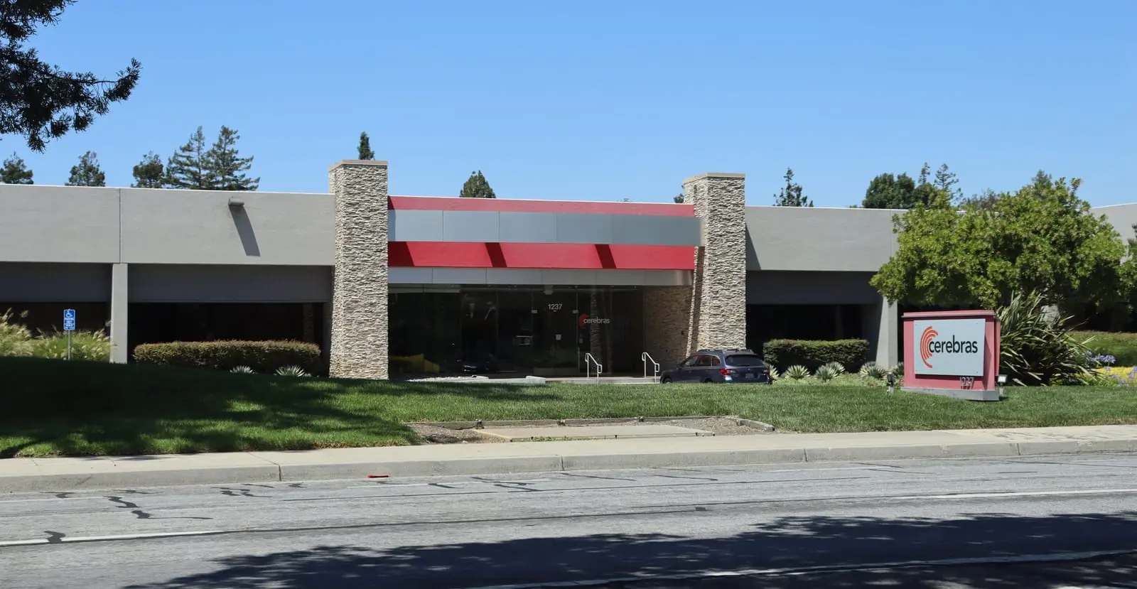 A low office building with a red and grey entrance and a red Cerebras sign on the lawn at 1237 East Arques Avenue in Sunnyvale.